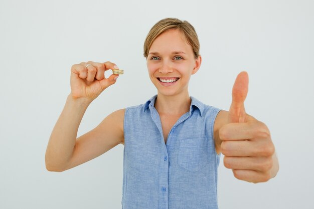 Sonriente, mujer, tenencia, monedas, actuación, pulgar, arriba