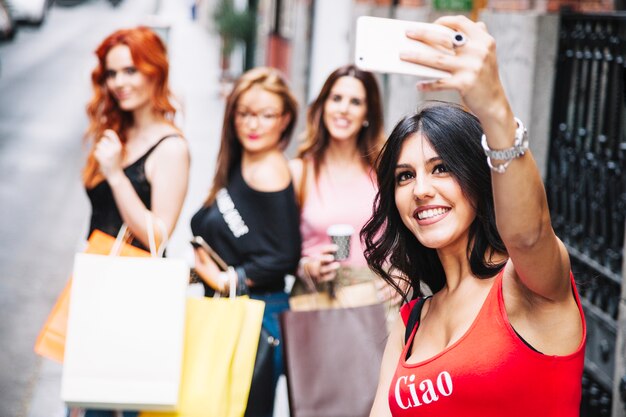 Sonriente mujer tomando selfies con sus amigos