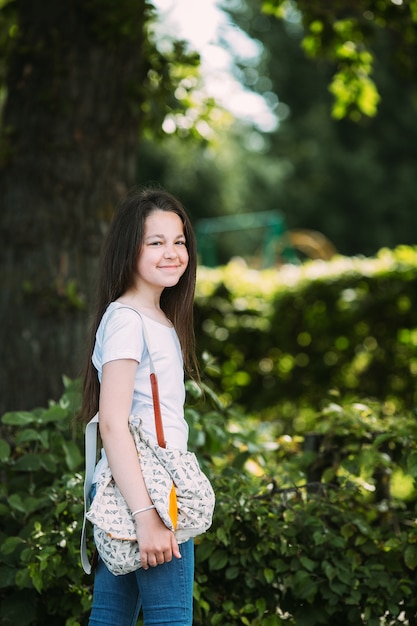 Sonriente, niña, bolsa, posición, sonriente