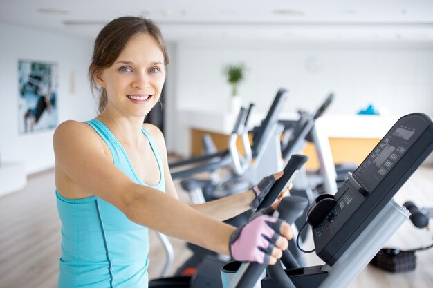 Sonriente, niña, entrenamiento, ejercicio, máquina, gimnasio