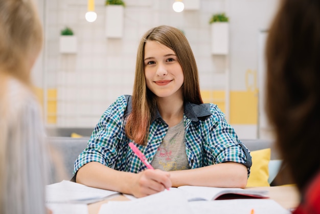 Sonriente niña estudiando en el aula