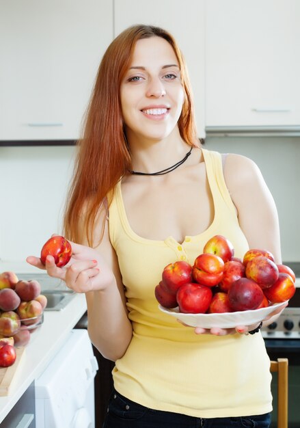 Foto gratuita sonriente niña con nectarinas