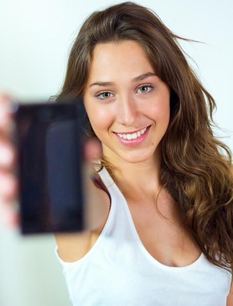 Foto gratuita sonriente niña pantalla del teléfono inteligente