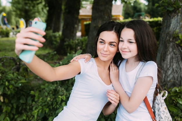 Sonriente, niñas, abrazar, toma, selfie