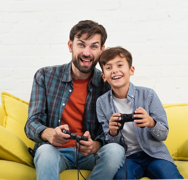 Sonriente niño y padre jugando en la consola