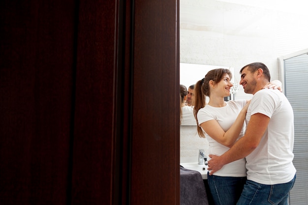 Foto gratuita sonriente pareja abrazándose en el baño