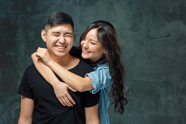 sonriente pareja coreana en gris