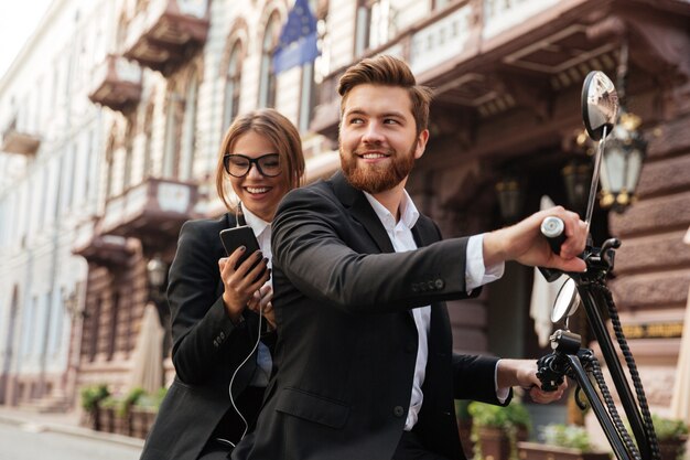 Sonriente pareja elegante monta en moto moderna