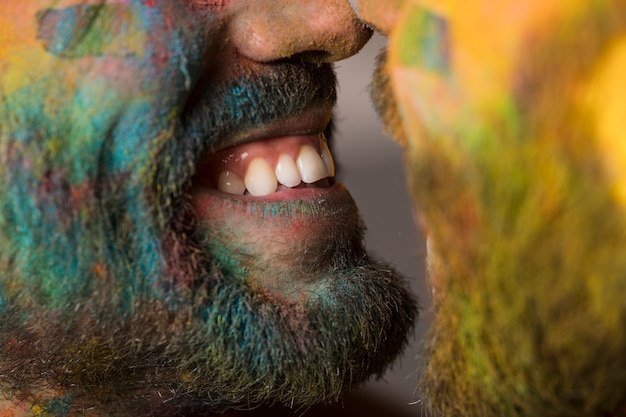 Sonriente pareja gay en polvo holi