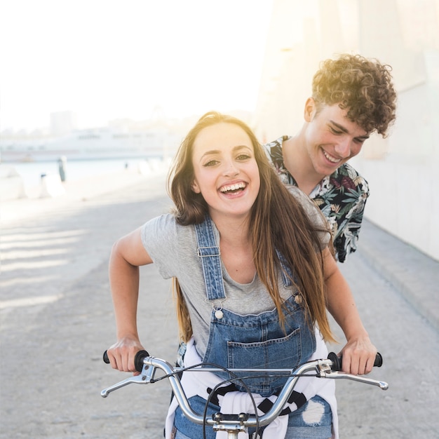 Sonriente pareja joven en bicicleta