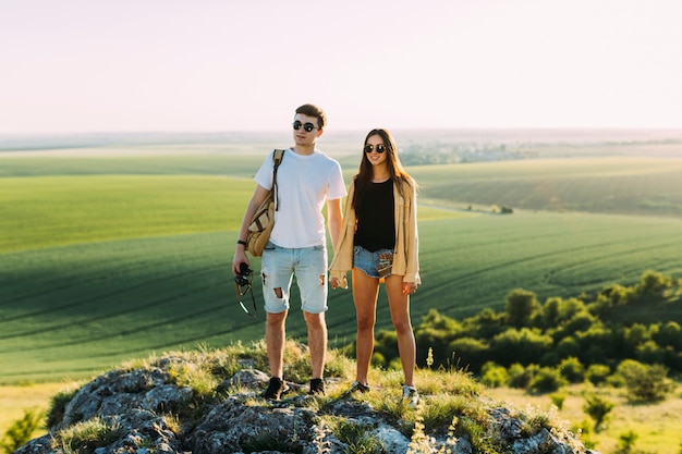 Foto gratuita sonriente, pareja joven, posición, en, roca