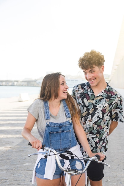 Sonriente pareja mirándose mientras conduce bicicleta