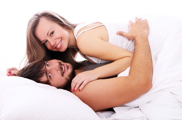 Sonriente pareja relajarse en la cama