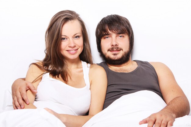 Sonriente pareja relajarse en la cama