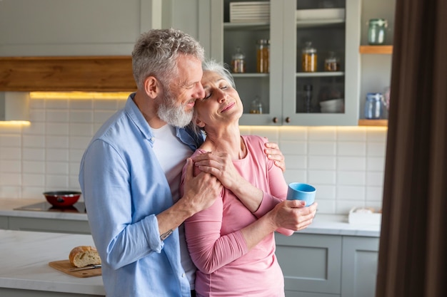 Sonriente pareja senior en cocina tiro medio