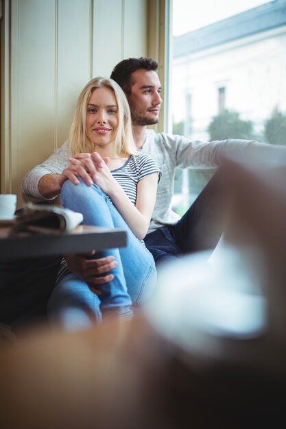 Sonriente pareja sentada con los brazos alrededor