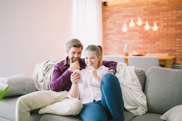 Sonriente pareja con teléfono inteligente