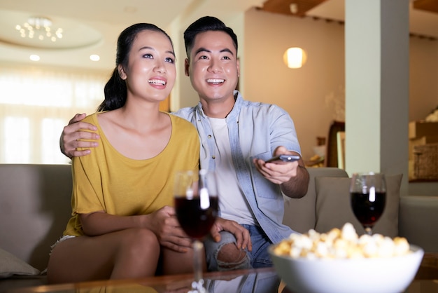 Sonriente pareja viendo la televisión en el sofá