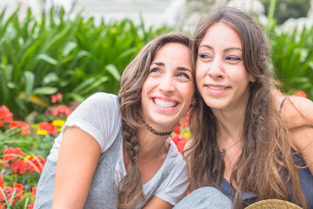 Sonrientes amigos sentados juntos en el parque