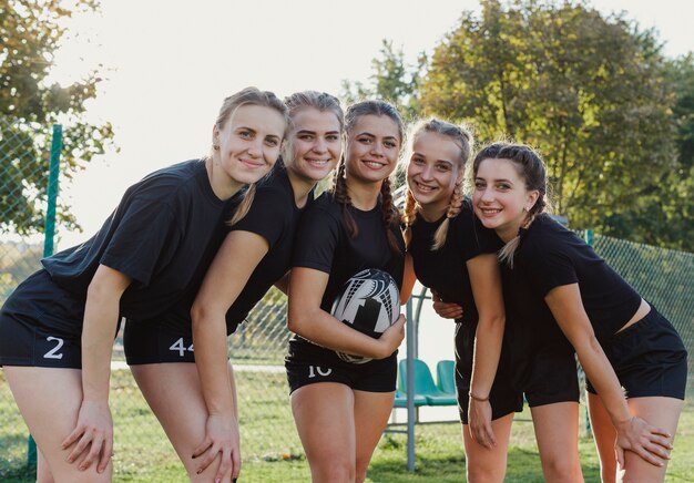 Sonrientes chicas deportivas mirando al fotógrafo