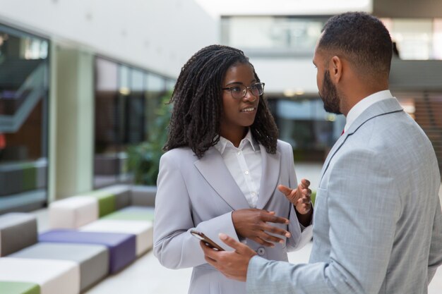 Sonrientes jóvenes empresarios hablando