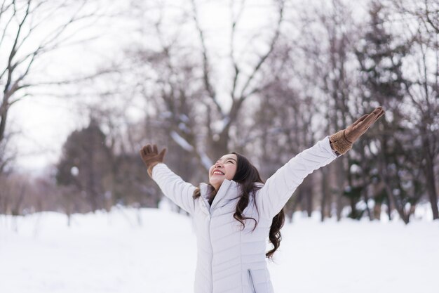 Sonrisa asiática joven hermosa de la mujer feliz para el viaje en la estación del invierno de la nieve