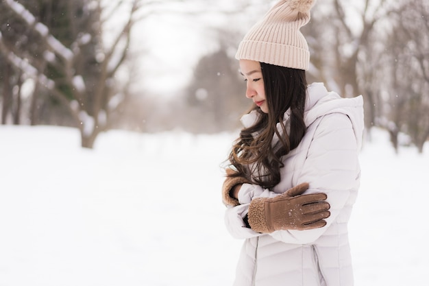 Sonrisa asiática joven hermosa de la mujer feliz para el viaje en la estación del invierno de la nieve