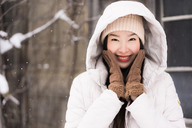 Foto gratuita sonrisa asiática joven hermosa de la mujer feliz para el viaje en la estación del invierno de la nieve