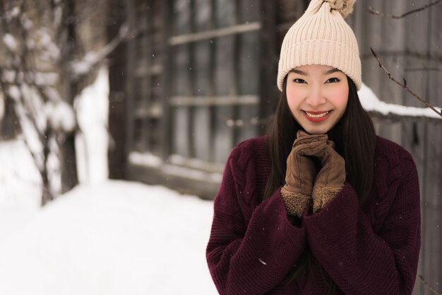 Sonrisa asiática joven hermosa de la mujer feliz para el viaje en la estación del invierno de la nieve