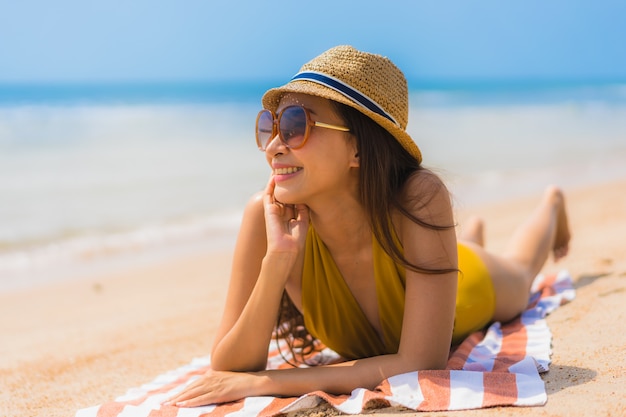 Foto gratuita sonrisa asiática joven hermosa de la mujer del retrato feliz en la playa y el mar