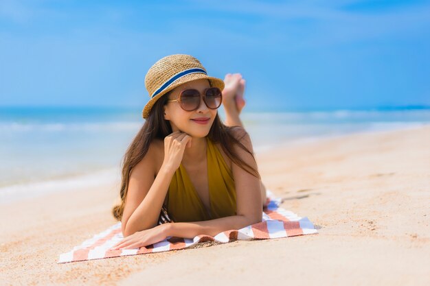 Sonrisa asiática joven hermosa de la mujer del retrato feliz en la playa y el mar