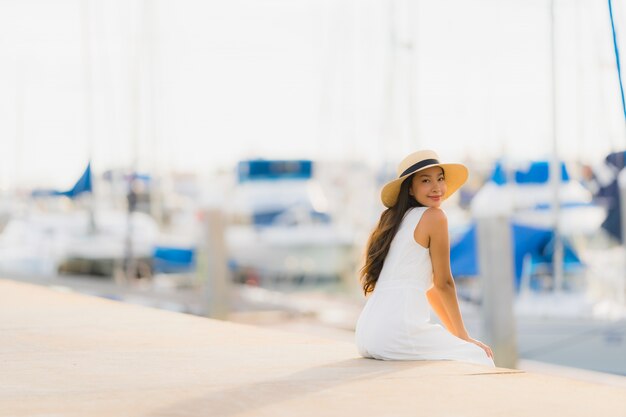 La sonrisa asiática joven hermosa del ocio de la mujer del retrato feliz se relaja alrededor de puerto del yate