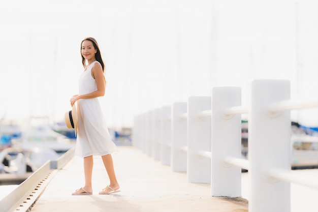 La sonrisa asiática joven hermosa del ocio de la mujer del retrato feliz se relaja alrededor de puerto del yate