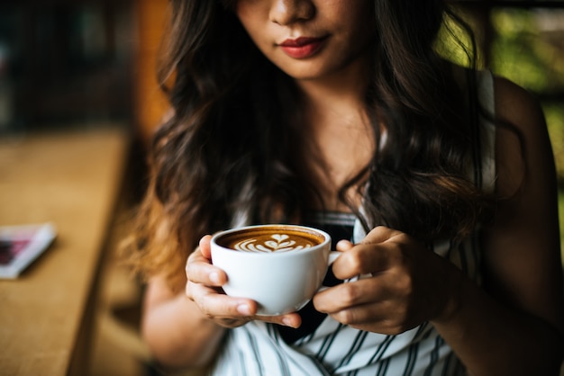 Foto gratuita la sonrisa asiática de la mujer del retrato se relaja en café de la cafetería