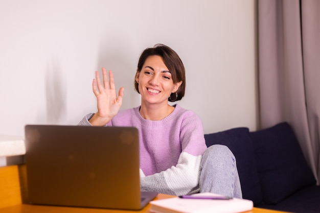 Foto gratuita sonrisa caucásica joven mujer niña en dormitorio en cámara de sonrisa de sofá