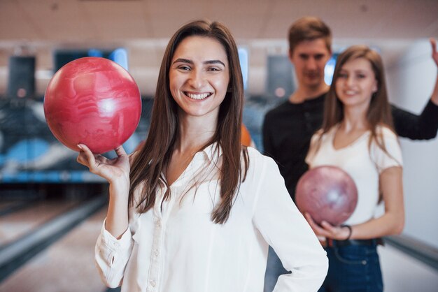 Sonrisa con dientes. Jóvenes amigos alegres se divierten en el club de bolos en sus fines de semana