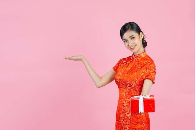 Foto gratuita sonrisa feliz hermosa mujer asiática y caja de regalo de celebración en año nuevo chino sobre fondo rosa.