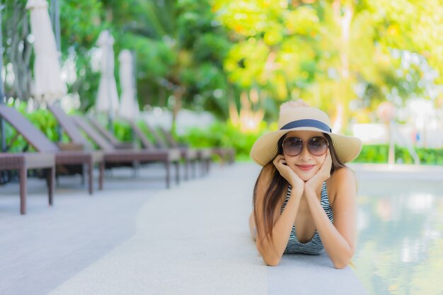 Sonrisa feliz de hermosas mujeres asiáticas jóvenes relajarse alrededor de la piscina al aire libre en el hotel resort