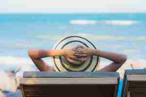 Foto gratuita la sonrisa feliz de la mujer asiática joven hermosa del retrato se relaja alrededor de la playa y del mar neary