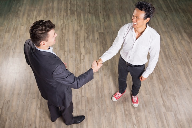 Foto gratuita la sonrisa hombres de negocios y estrechar la mano reunión