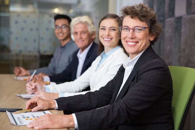 La sonrisa de negocios de alto nivel en la reunión con el equipo