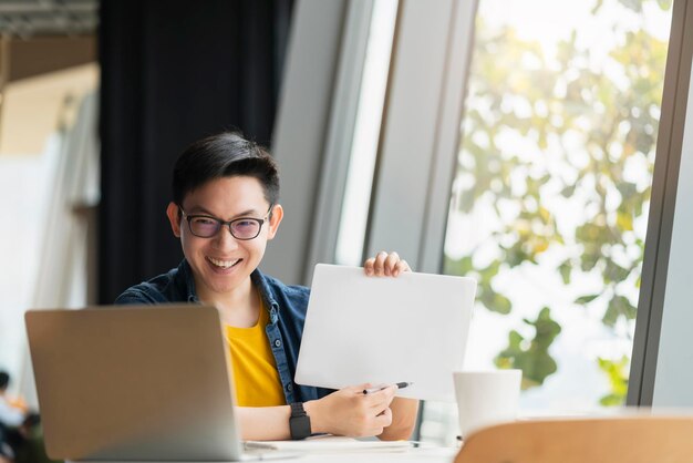 Sonrisa positiva inteligente hombre de negocios asiático videoconferencia trabajo remoto discutir la preocupación sobre la estrategia de planificación empresarial nuevas ideas de inicio de negocios concepto reunión de negocios en línea a través de una computadora portátil