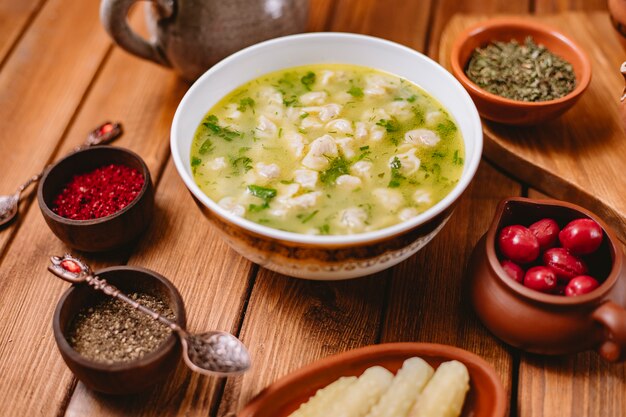 Sopa de albóndigas Dushbara servida con hierbas secas y especias horizontales