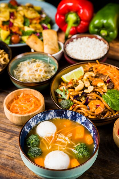 Sopa de bolas de pescado y plato de fideos en el escritorio de madera