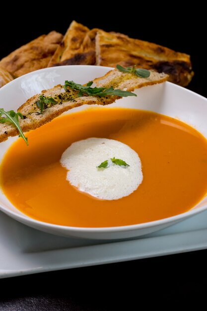 Sopa de calabaza con bollos de espuma de leche galletas de rúcula vista lateral