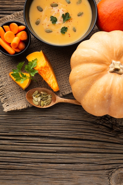 Foto gratuita sopa de calabaza plana puesta zanahorias y calabaza con espacio de copia