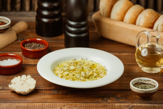 Sopa de caldo de pollo con hierbas en un plato blanco