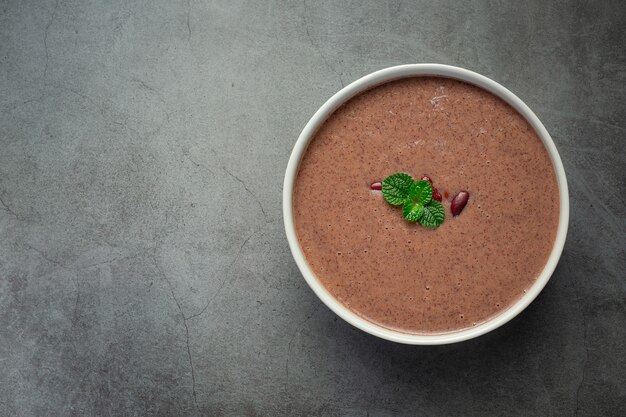 Sopa caliente de frijoles rojos en un tazón blanco lugar sobre un piso oscuro