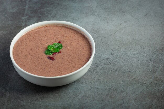 Sopa caliente de frijoles rojos en un tazón blanco lugar sobre un piso oscuro