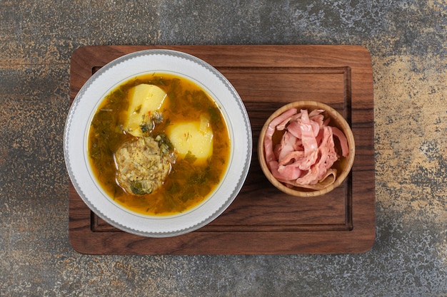 Foto gratuita sopa casera con albóndigas sobre tabla de madera.